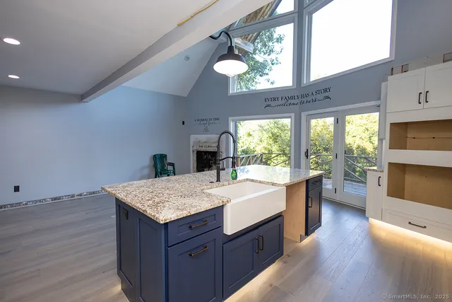 a kitchen with a wooden floor and large windows