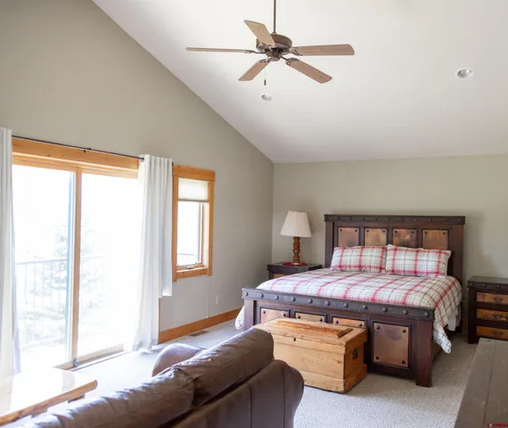a bedroom with a bed a chandelier and a window