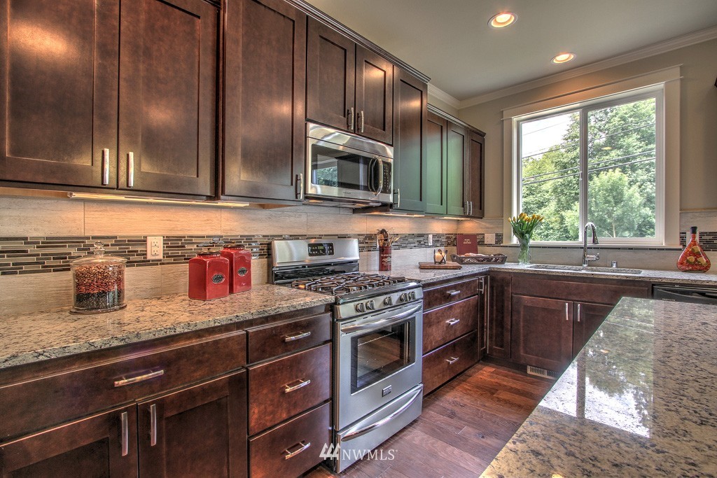 2405 196th Place Southeast, Unit 2 Bothell, WA 98012 - Photo 3 of 14 a kitchen with stainless steel appliances granite countertop wooden cabinets and a stove top oven