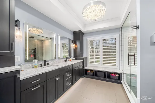 a spacious bathroom with a bathtub a sink and a large mirror