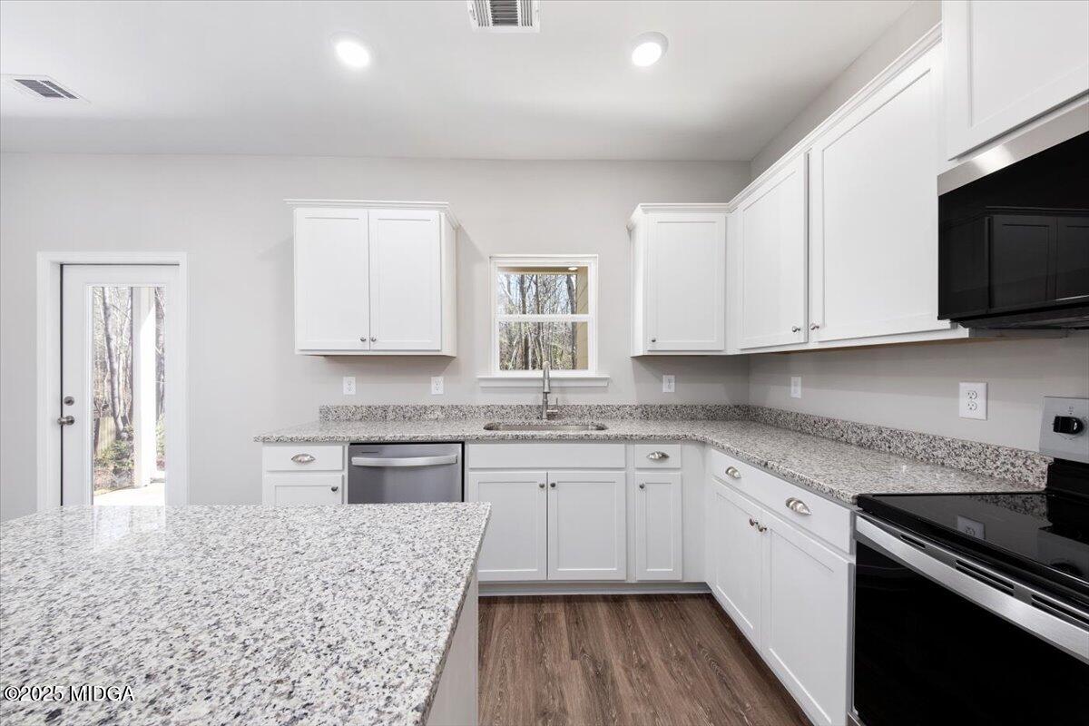 372 Walnut Grove Road Gray, GA 31032 - Photo 7 of 21 a kitchen with granite countertop cabinets stainless steel appliances a sink and wooden floor
