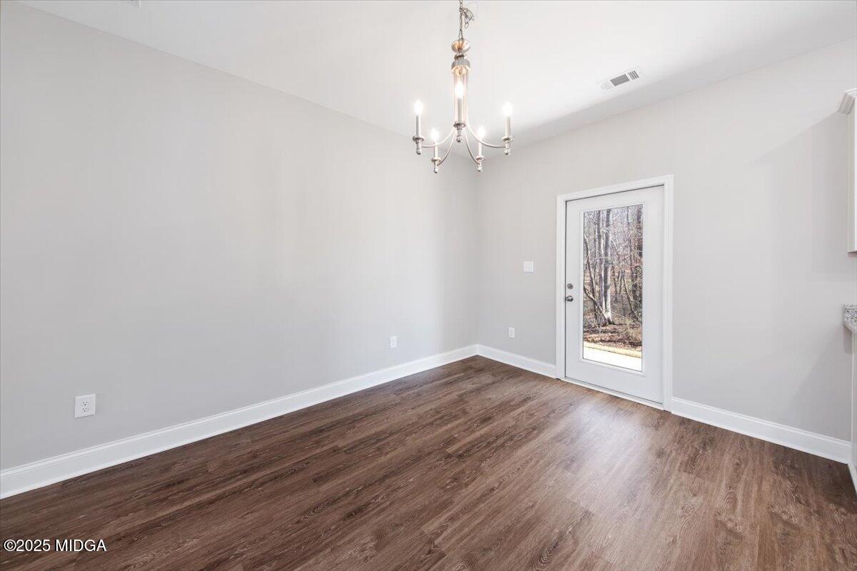 372 Walnut Grove Road Gray, GA 31032 - Photo 8 of 21 an empty room with wooden floor chandelier and windows