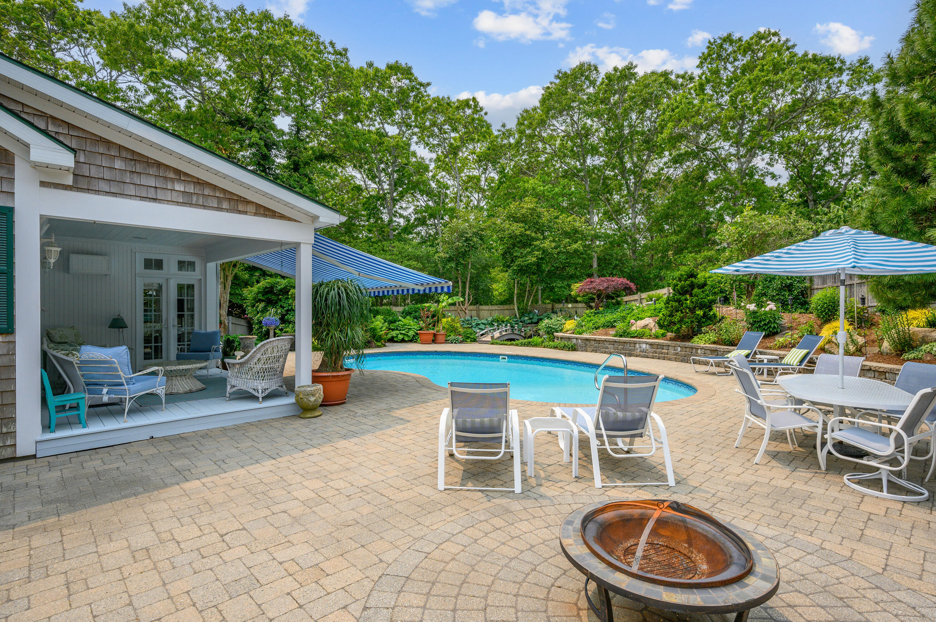 256 Pleasant Bay Road Harwich, MA 02645 - Photo 38 of 71 a view of a patio with table and chairs under an umbrella