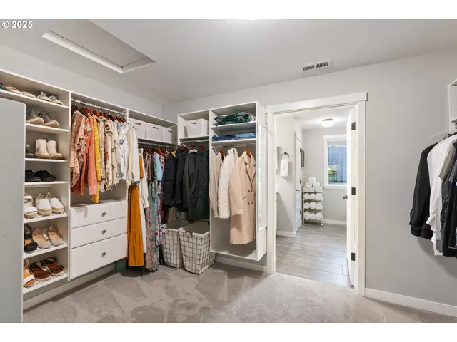 a view of walk in closet with clothes and shoes