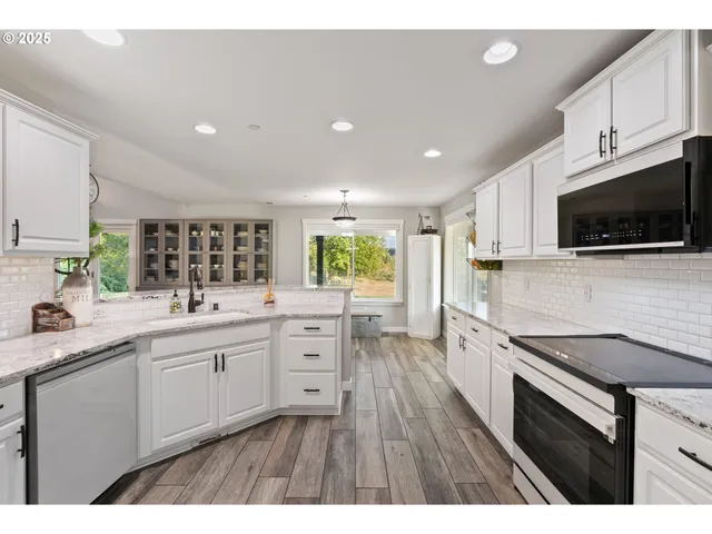 a kitchen with stainless steel appliances a stove sink microwave and cabinets