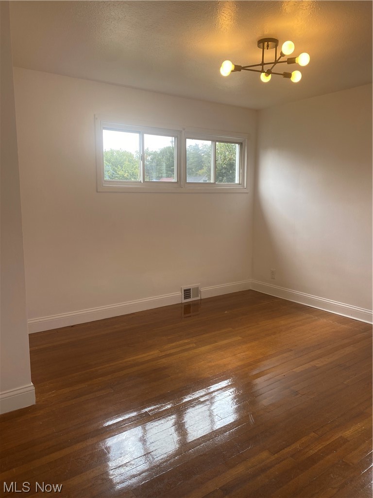 12913 Silver Road Cleveland, OH 44125 - Photo 12 of 23 1st floor bedroom featuring a healthy amount of sunlight and dark hardwood floors