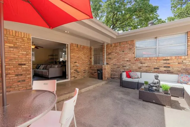 a view of a patio with a table and chairs under an umbrella