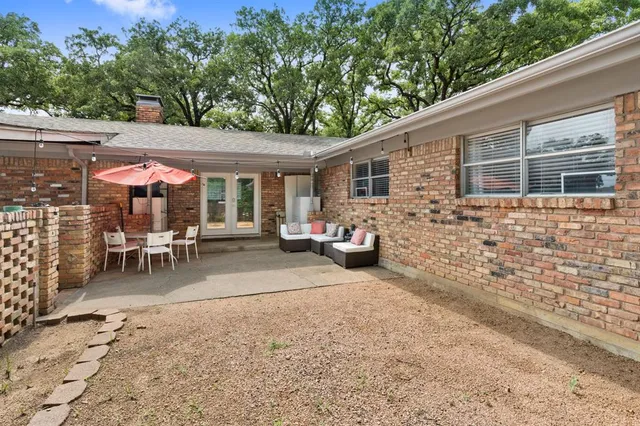 a view of a patio with a table and chairs under an umbrella