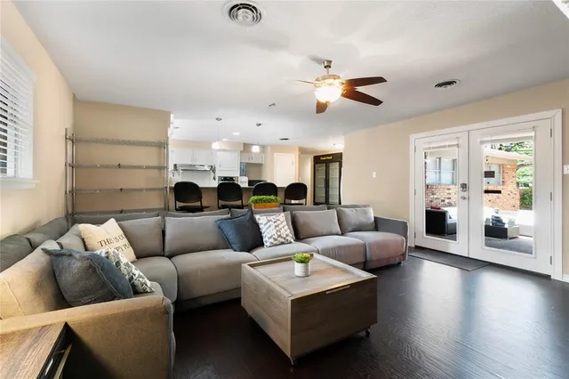 a living room with furniture kitchen view and a wooden floor
