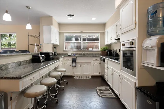 a large white kitchen with lots of counter space and window