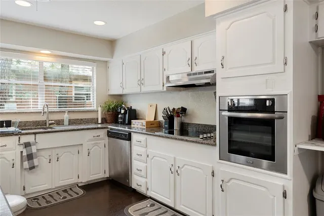 a kitchen with white cabinets and appliances