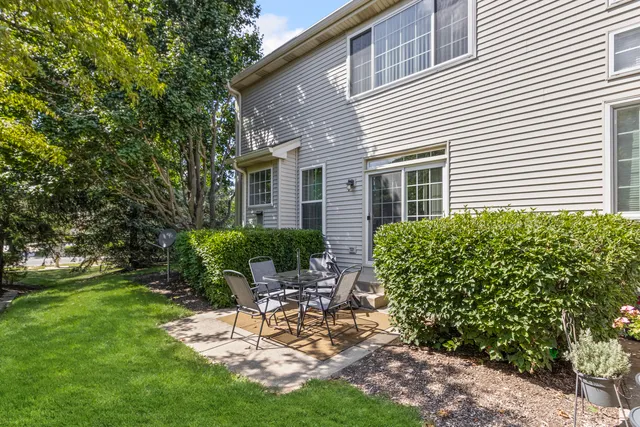 a view of a chair and table in backyard of the house