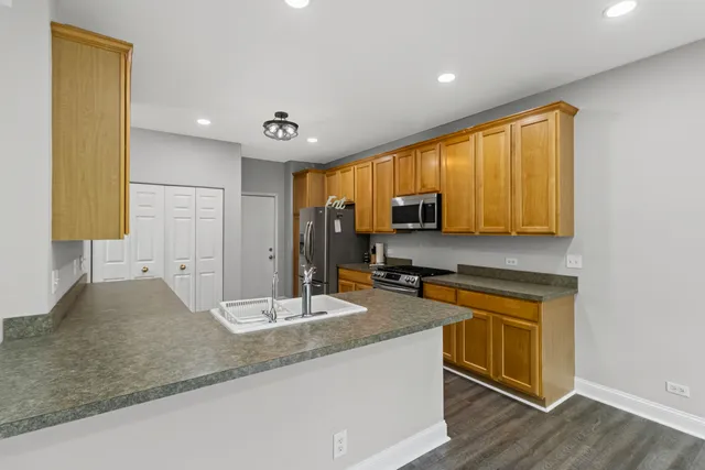 a kitchen with stainless steel appliances granite countertop a sink a stove and a refrigerator
