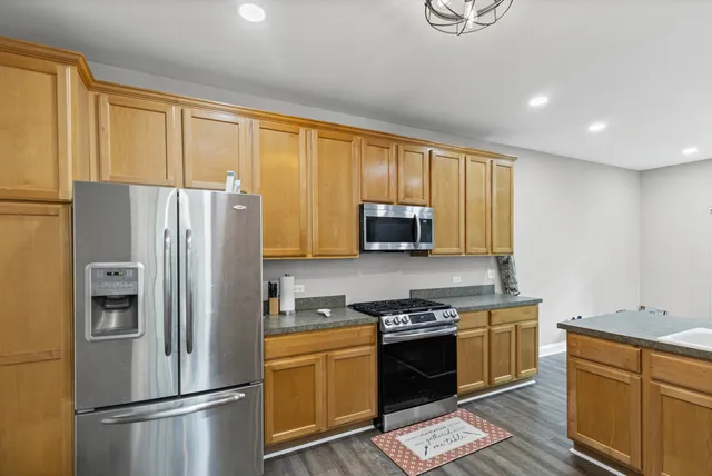 a kitchen with stainless steel appliances granite countertop a refrigerator stove and sink