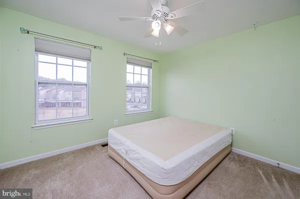 a bed sitting in a bedroom next to a window