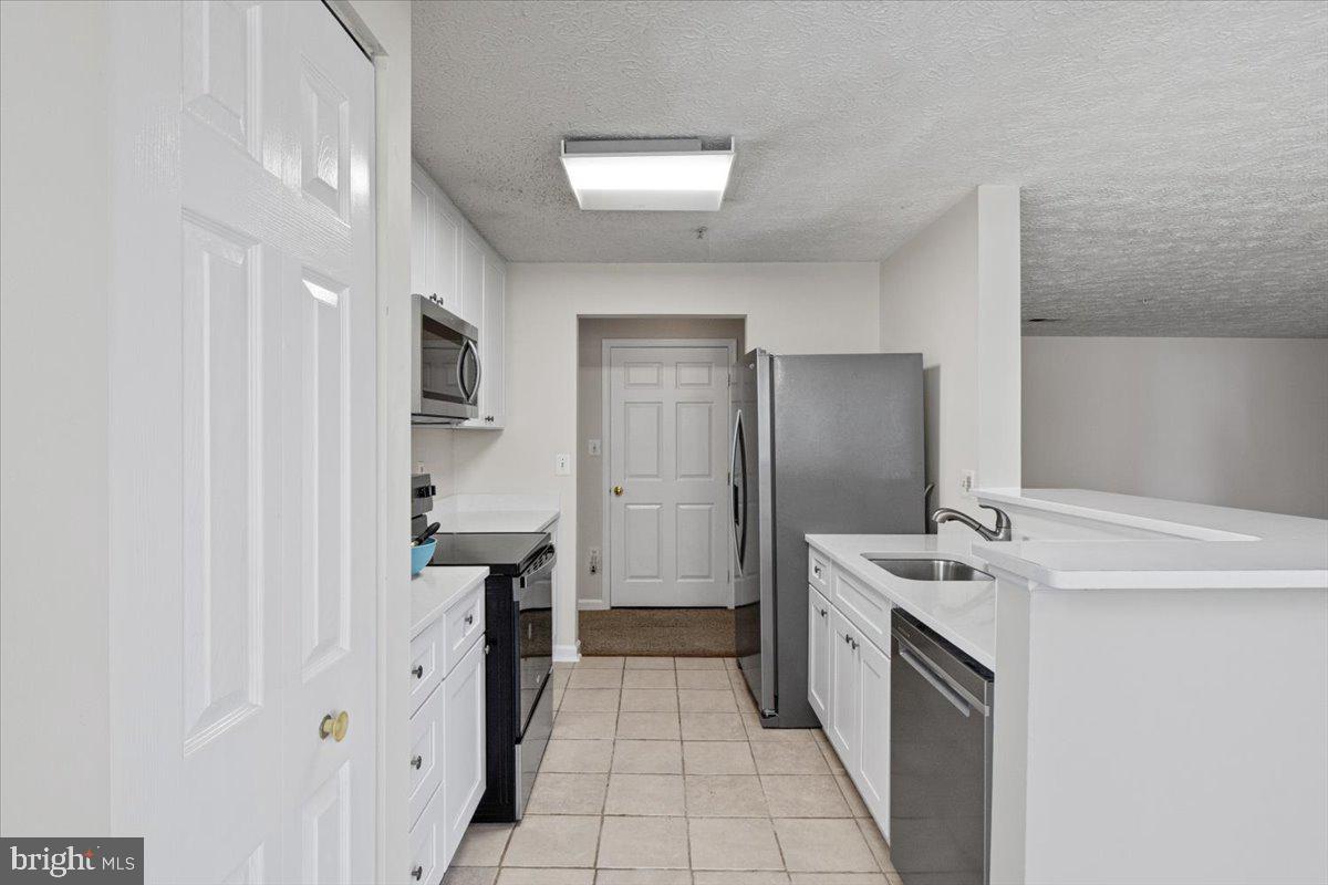 2445 Blue Spring Court, Unit 103 Odenton, MD 21113 - Photo 11 of 31 a kitchen with a sink and refrigerator