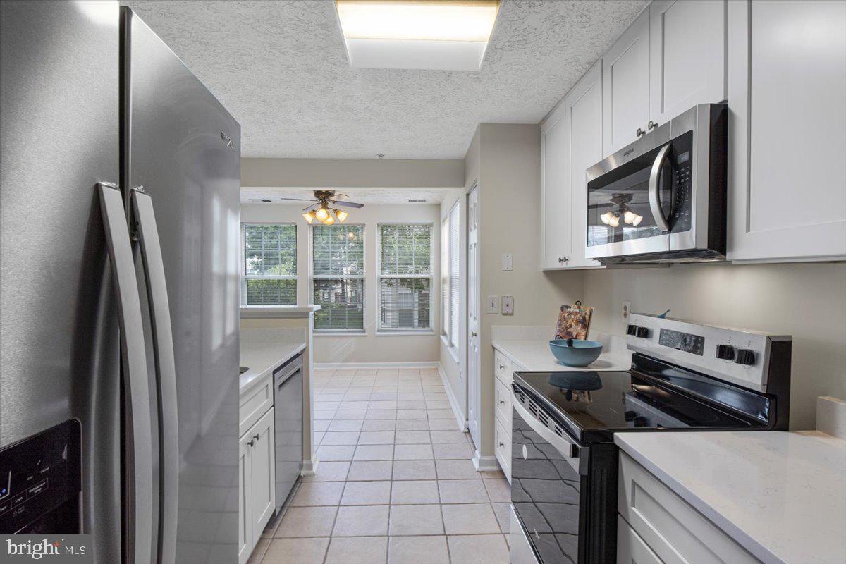 2445 Blue Spring Court, Unit 103 Odenton, MD 21113 - Photo 12 of 31 a kitchen with stainless steel appliances a stove microwave and refrigerator