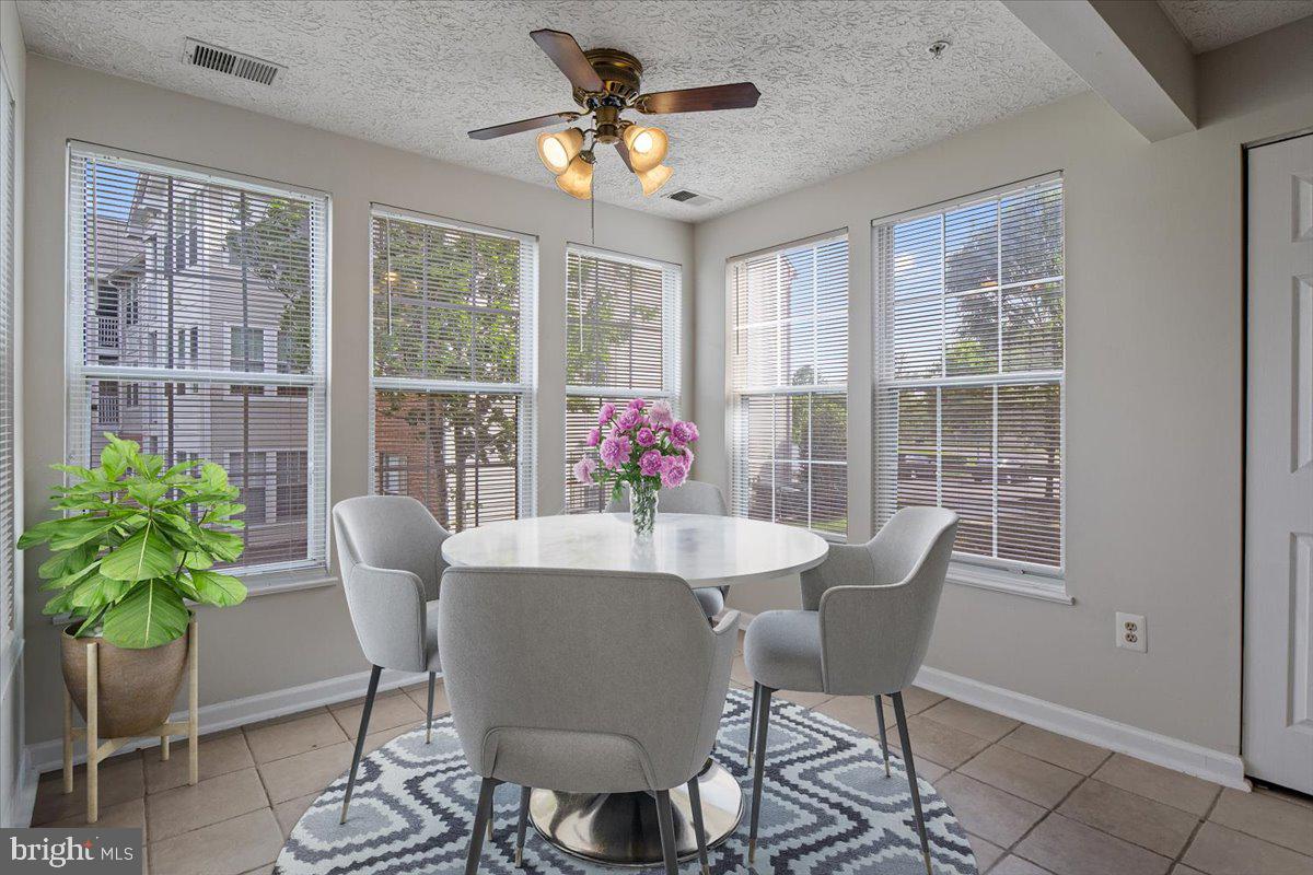 2445 Blue Spring Court, Unit 103 Odenton, MD 21113 - Photo 14 of 31 a dining room with furniture potted plants and wooden floor