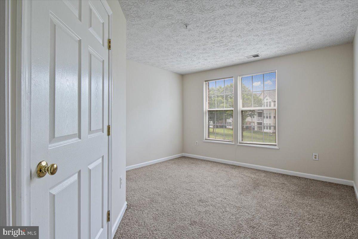 2445 Blue Spring Court, Unit 103 Odenton, MD 21113 - Photo 26 of 31 an empty room with windows