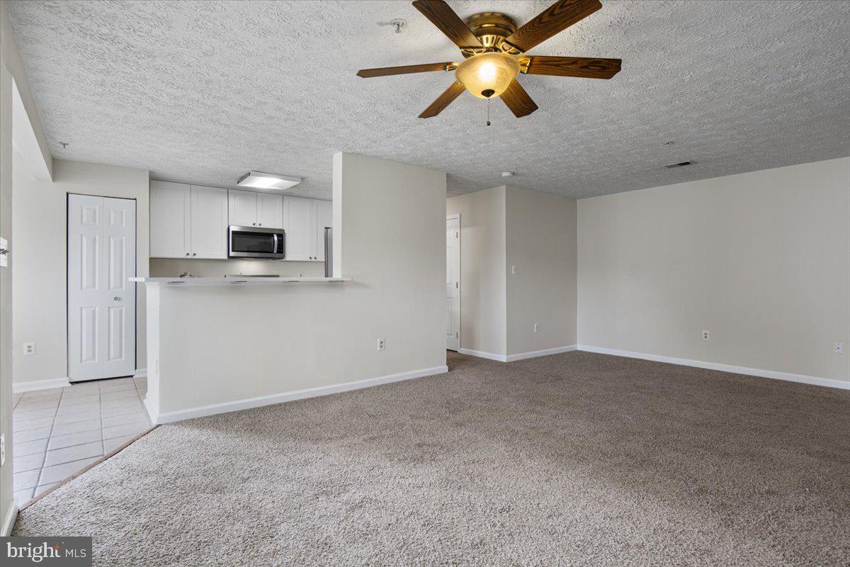 2445 Blue Spring Court, Unit 103 Odenton, MD 21113 - Photo 7 of 31 a view of a kitchen with a sink and a chandelier fan