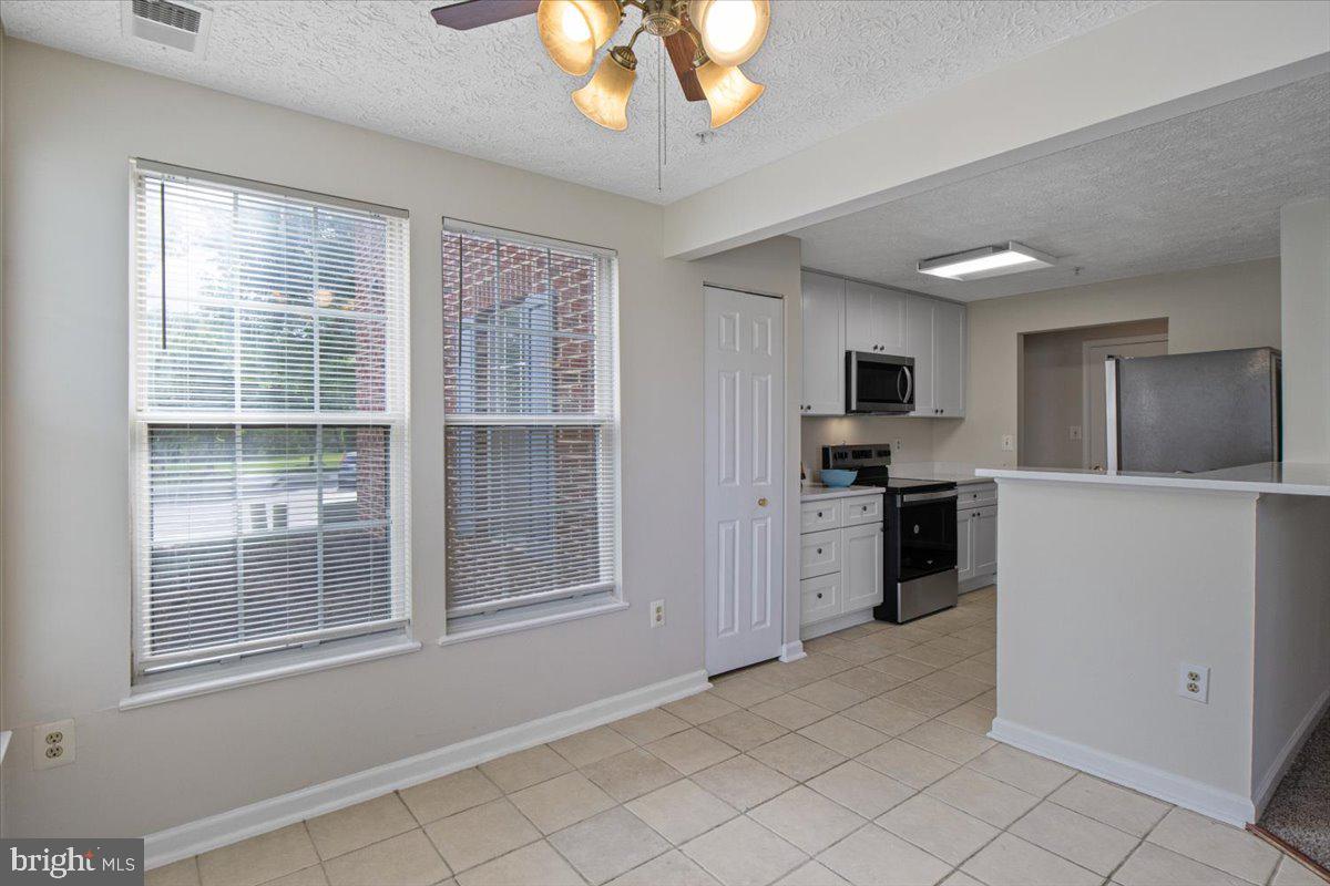 2445 Blue Spring Court, Unit 103 Odenton, MD 21113 - Photo 8 of 31 a large white kitchen with cabinets