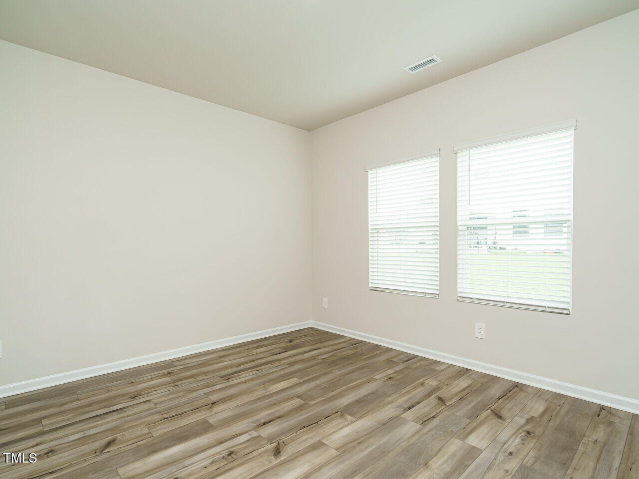 792 Riguard Way Wendell, NC 27591 - Photo 10 of 46 an empty room with wooden floor and windows