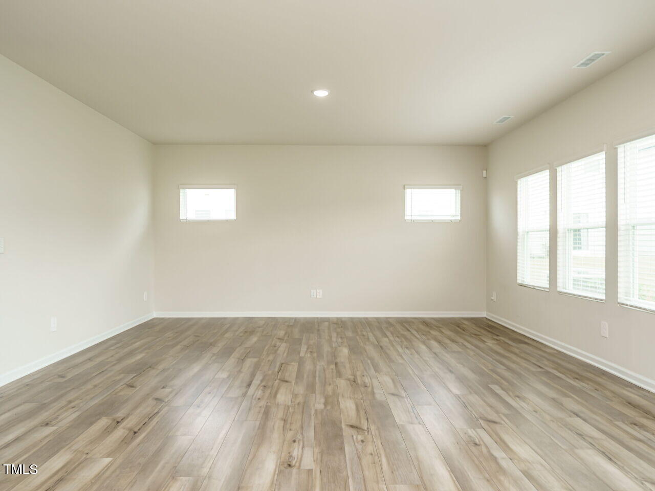 792 Riguard Way Wendell, NC 27591 - Photo 12 of 46 an empty room with wooden floor and windows