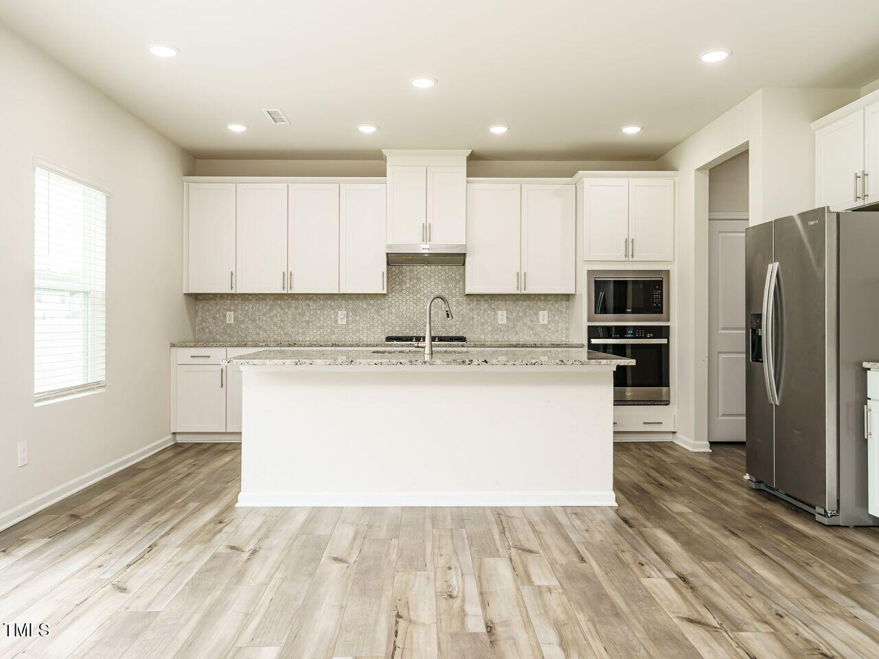792 Riguard Way Wendell, NC 27591 - Photo 17 of 46 a large kitchen with kitchen island a sink a center island stainless steel appliances and a window