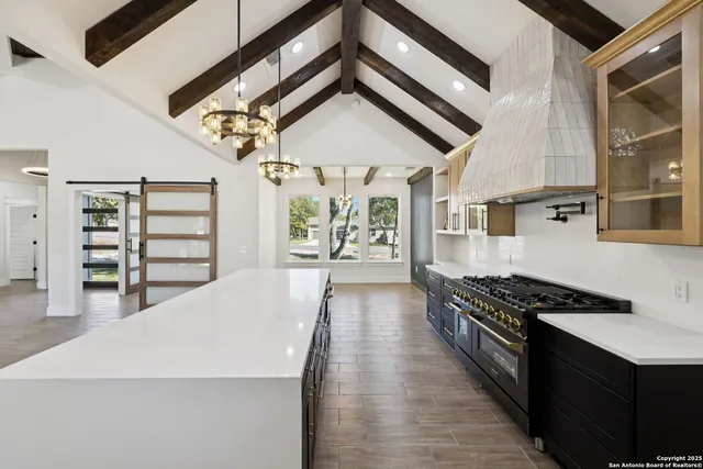 a kitchen with stainless steel appliances a stove a window and wooden floor