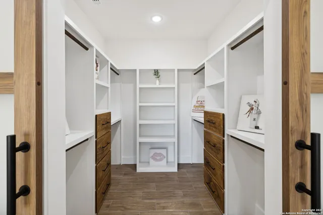 a view of walk in closet with empty racks