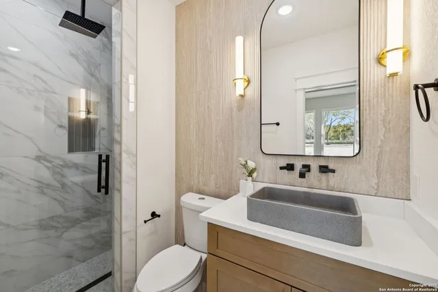 a bathroom with a sink a toilet and a mirror