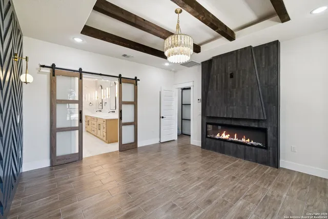 a view of an empty room with a fireplace and wooden floor