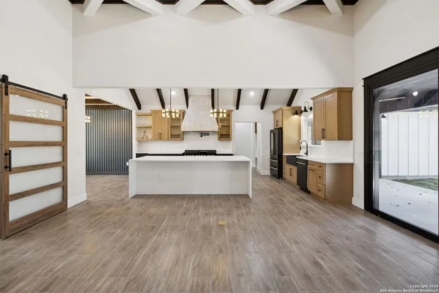 a living room with stainless steel appliances kitchen island granite countertop a refrigerator and a stove top oven