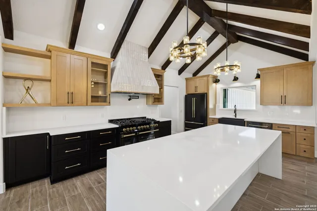 a kitchen with stainless steel appliances granite countertop a sink a stove and a wooden floors