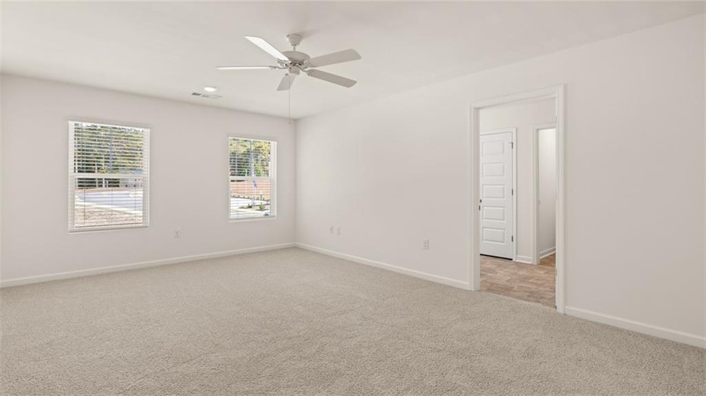 1910 Van Alen Court Dacula, GA 30019 - Photo 12 of 64 an empty room with windows and fan