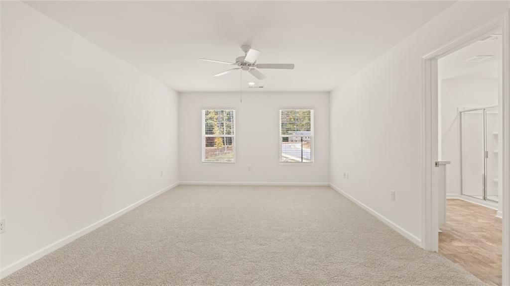 1910 Van Alen Court Dacula, GA 30019 - Photo 14 of 64 an empty room with windows and chandelier fan