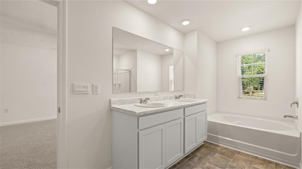 1910 Van Alen Court Dacula, GA 30019 - Photo 15 of 64 a bathroom with a sink double vanity granite tub and mirror