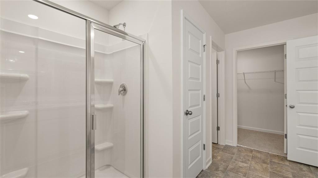 1910 Van Alen Court Dacula, GA 30019 - Photo 16 of 64 a bathroom with a glass shower door
