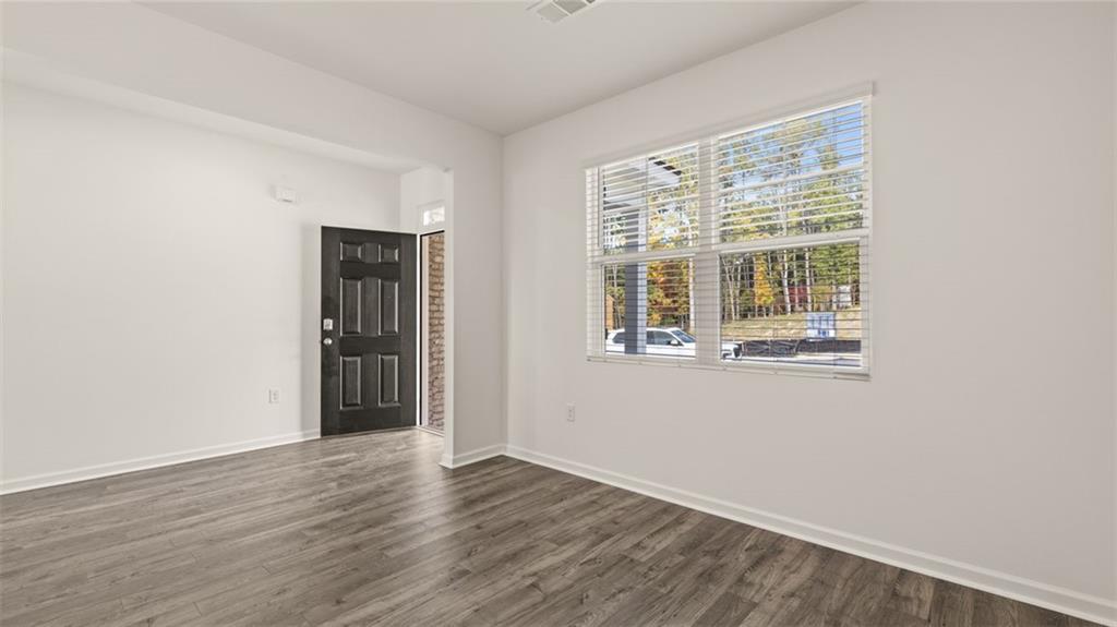 1910 Van Alen Court Dacula, GA 30019 - Photo 19 of 64 a view of an empty room with wooden floor and a window