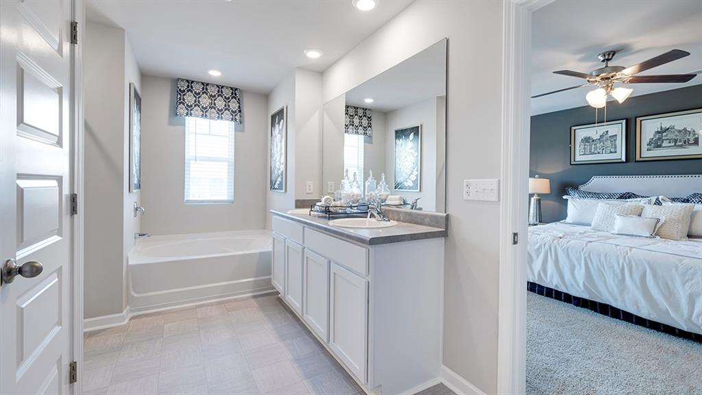 1910 Van Alen Court Dacula, GA 30019 - Photo 41 of 64 a spacious bathroom with a double vanity sink a mirror and a bathtub
