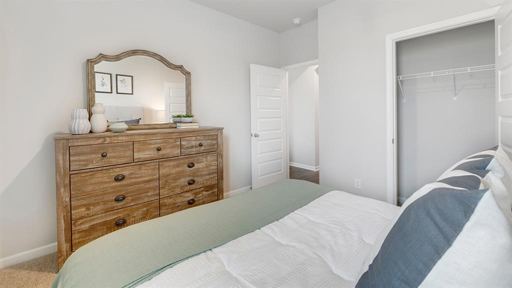 1910 Van Alen Court Dacula, GA 30019 - Photo 49 of 64 a bedroom with a bed and a mirror