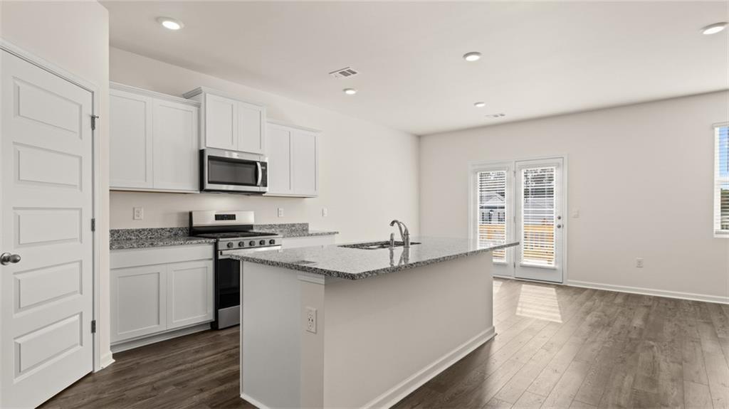 1910 Van Alen Court Dacula, GA 30019 - Photo 6 of 64 a kitchen with stainless steel appliances granite countertop a sink stove and microwave