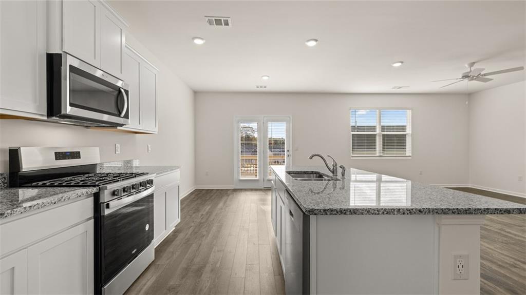 1910 Van Alen Court Dacula, GA 30019 - Photo 9 of 64 a kitchen with granite countertop a stove sink and microwave