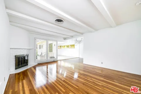 a view of empty room with wooden floor and fireplace