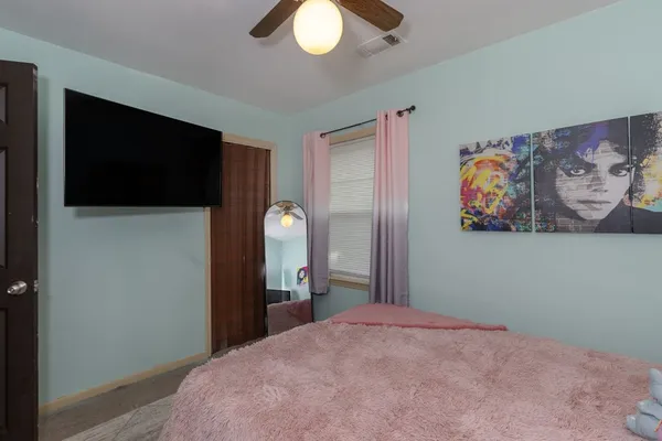 a bedroom with a bed and a flat screen tv