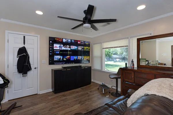 a living room with wooden floor furniture and a flat screen tv