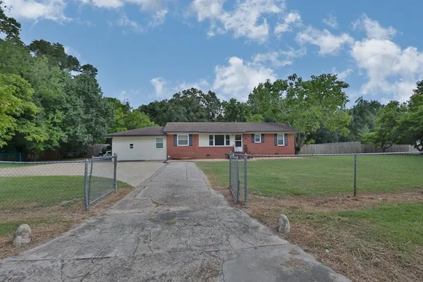 a view of a house with backyard and trees
