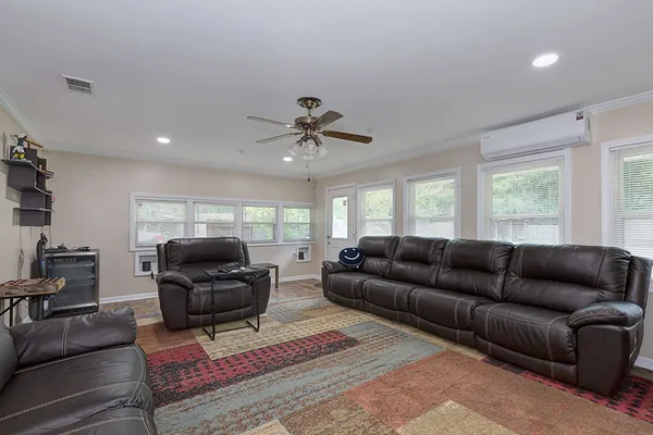 a living room with furniture a ceiling fan and a window