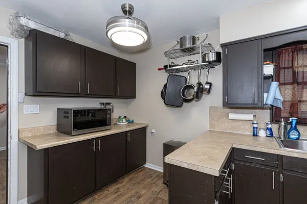 a kitchen with stainless steel appliances granite countertop a sink dishwasher stove top oven and cabinets with wooden floor