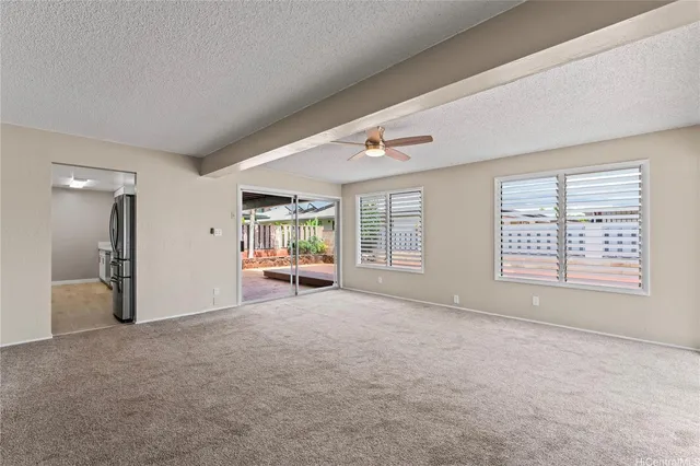a view of an empty room with a window and a bathroom